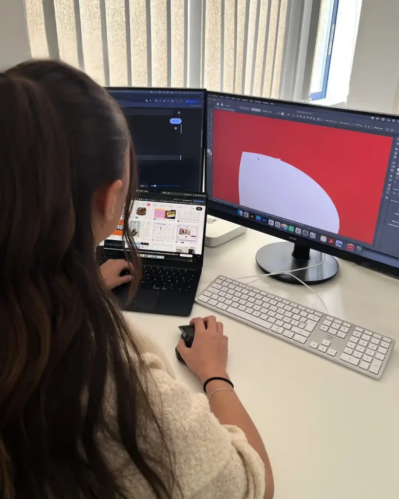 Graphiste travaillant sur la création d'une identité visuelle sur plusieurs écrans.